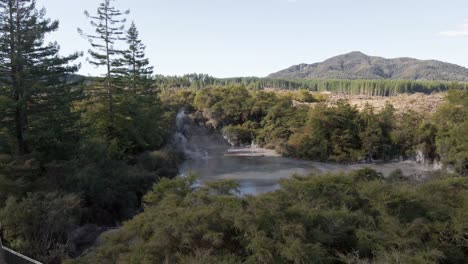 Ascending-aerial-revealing-shot-of-the-surrounding-area-of-the-Waiotapu-Mud-Pools,-Rotorua,-New-Zealand