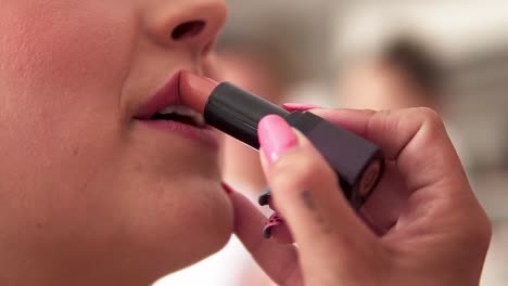 Slow-motion-handheld-close-zp-shot-of-a-bride-being-made-up-by-a-make-up-stylist-for-her-wedding-with-her-husband-while-lipstick-is-being-applied
