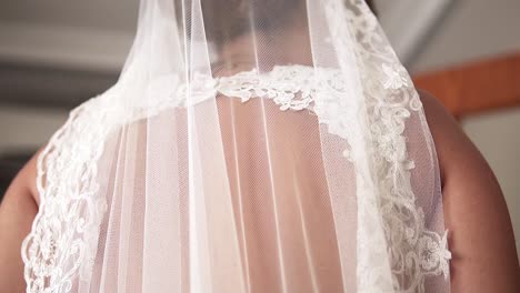 Slow-motion-descending-shot-of-the-back-of-a-bride-dressed-in-a-white-wedding-dress-before-her-wedding-with-her-husband