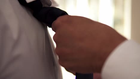 Slow-motion-handheld-close-up-shot-of-groom-getting-ready-for-his-wedding-with-bride-and-having-his-tie-tied-on-wedding-day