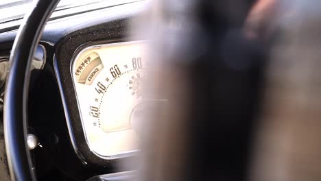 Slow-motion-close-up-panning-shot-from-a-dashboard-of-a-vintage-car-or-oldtimer-with-a-classy-retro-style-analog-speed-display