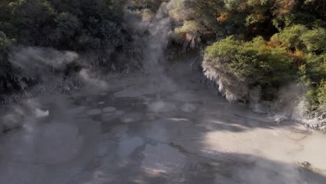 Slow-aerial-ascent-above-a-boiling-mud-pool-in-Waiotapu,-Rotorua,-New-Zealand