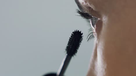 Gorgeous-woman-applying-mascara-to-eyelids,-extreme-closeup-shot