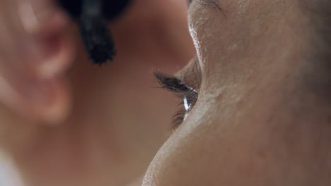 Closeup-mature-woman-applying-eyeliner