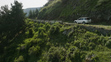 Car-driving-through-winding,-mountain-road---shot-revealing-dreamy-landscape