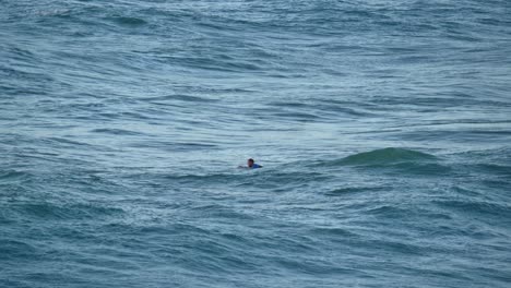 Un-Hombre-Navegando-Solo-En-Una-Tabla-De-Surf-En-El-Océano-Azul-En-Haderah,-Israel