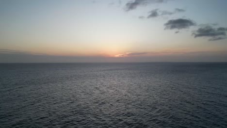 Sunset-over-the-Indian-Ocean-at-Kusini-beach-East-Zanzibar-Island,-Tanzania-Africa,-Aerial-rising-shot