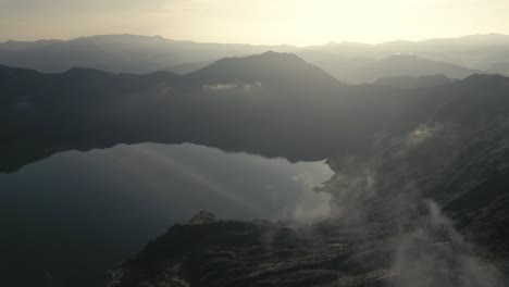 Golden-Sunrise,-Aerial-Above-Quilotoa-Crater-Lake,-Still-Water-Reflex,-Ecuador,-Drone-Fly-The-Andes-Volcano,-Popular-South-American-Hiking-Destination