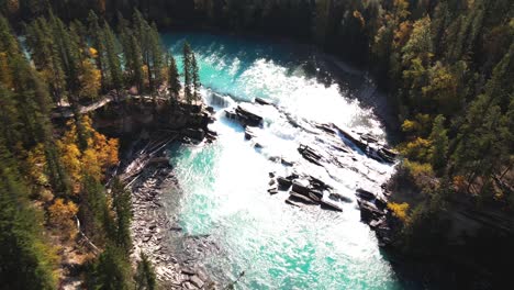 flying-down-aerial-zoom-in-shot-of-Rearguard-Falls-drone-flying-over-forest-towards-the-waterfalls-on-a-sunny-day-in-autumn-in-a-forest-environment-and-the-fraser-river