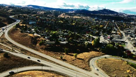 truck-right-drone-shot-hyperlapse-of-Kamloops-BC-Canada-with-Bridges-and-the-Highway-1-and-Yellowhead-Highway-5-on-a-sunny-day-in-the-desert-city-with-cars-and-semi-trucks-driving-in-the-foreground