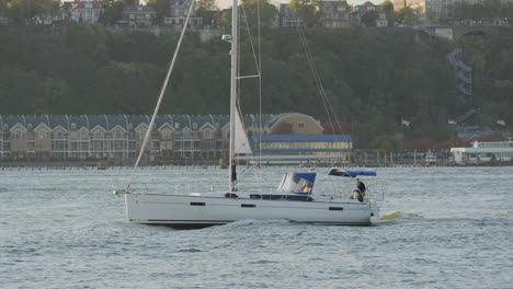 Segelboot-Mit-Einem-Mast,-Der-Während-Des-Sonnenuntergangs-Entlang-Des-Hudson-River-Fährt,-Mit-New-Jersey-Im-Hintergrund