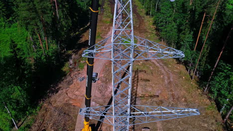 Aerail-drone-tilt-down-shot-of-electrical-technicians-installing-power-lines-on-the-newly-installed-electric-pole-at-daytime