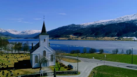 Drone-forward-moving-shot-flying-over-Jostedal-church-which-is-a-parish-church-in-Luster-Municipality-in-Sogn-of-Fjordane-county,-Norway-ona-sunny-day