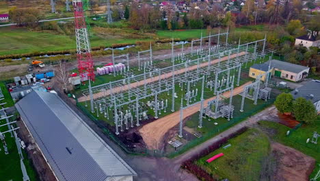 Aerial-drone-forward-moving-shot-taken-over-a-high-voltage-power-distribution-substation-at-daytime
