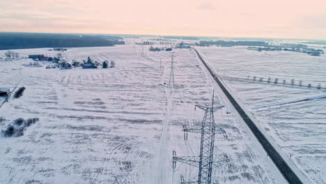 Aerial-drone-forward-moving-shot-over-white-snow-covered-farmland-on-a-cloudy-day