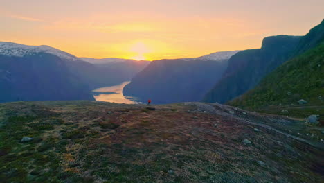 Luftdrohnenaufnahmen,-Die-über-Die-Bergspitze-Fliegen,-Zeigen-Die-Wunderschöne-Landschaft-Des-Fjords,-Umgeben-Von-Einer-Bergkette-In-Aurland,-Norwegen