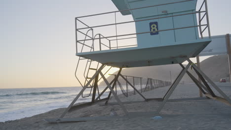 Aufsteigender-Schuss-Des-Rettungsschwimmerturms-Am-Strand-Von-Mondo-Bei-Sonnenuntergang-In-Südkalifornien