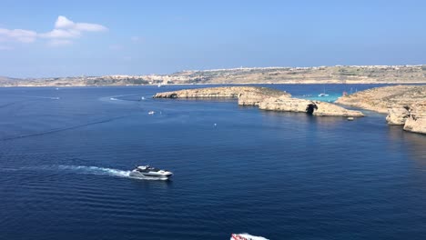 Barco-Rápido-Entrando-En-La-Bahía-De-La-Próxima-Isla-En-Malta-Durante-Un-Día-Soleado-De-Destino-Turístico-De-Vacaciones-De-Verano