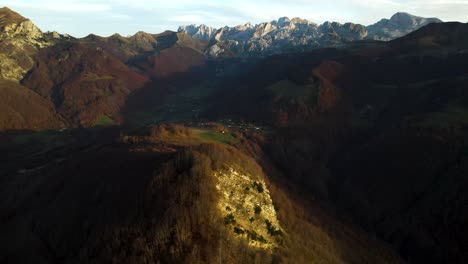 Sunset-over-alpine-mountains-and-valleys-with-green-grass-surrounded-by-forests-in-autumn,-Albania