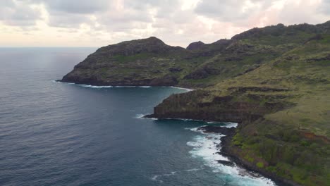 Luftbild-4k-Aufnahmen-Von-Drohnen-Von-Ozeanblauen-Wellen,-Die-Auf-Einer-Hohen-Klippe-Eines-Felsigen-Berges-Brechen