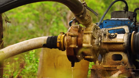 Leaking-rusty-old-water-pump-working-with-petrol-engine-to-pump-liquid-upward