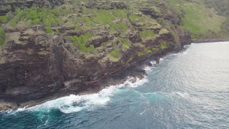 Dramatic-footage-of-azure,-blue,-green,-turquoise-waves-crashing-on-scenic-black-volcanic-sea-cliffs-and-sharp-rocks