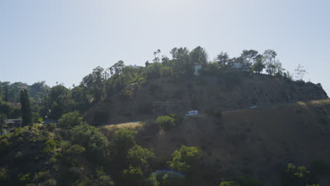 Tracking-shot-of-delivery-truck-driving-down-windy-mountain-road-located-in-the-Hollywood-Hills-Southern-California