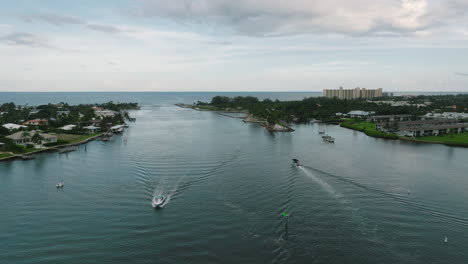 Drone-shot-of-the-Jupiter-Inlet-with-boats-passing-in-Jupiter,-Florida