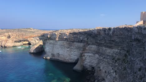 comino-island-panoramic-wide-angle-shot-of-rock-cliff-with-mediterranea-sea-bay-luxury-sail-boat-moored