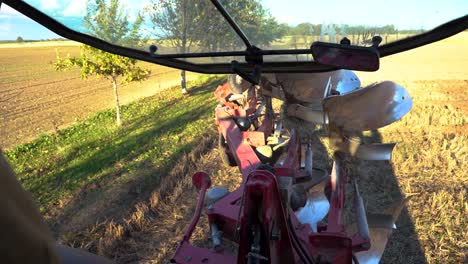 Person-driving-tractor-backward-to-begin-plowing-soil,-POV