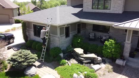 Drone-shot-of-a-Gutter-inspection-from-a-ladder-by-a-handy-man-carpenter