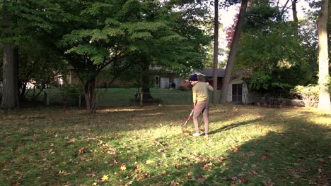 A-man-raking-leaves-into-a-pile-on-a-chilly-Autumn-Day