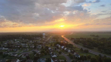 Drone-flying-towards-the-watertower-in-Clarksville-revealing-a-beautiful-sunrise-with-clouds-in-the-sky