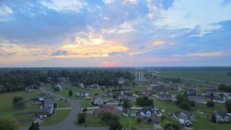 Aerial-view-of-the-watertower-in-Clarksville-with-a-bus-on-the-road-at-beautiful-sunrise-with-clouds-in-the-sky