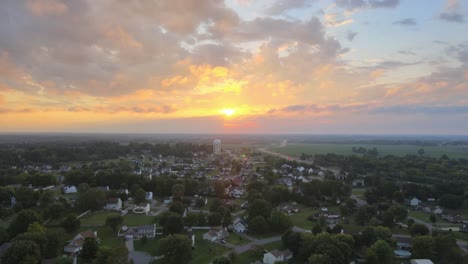 Orbit-aerial-shot-of-the-watertower-far-away-in-Clarksville-with-beautiful-sunrise-at-background