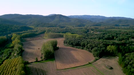 Campo-Para-El-Cultivo-De-La-Tierra-Con-árboles-Y-Montañas-En-El-Fondo-Al-Lado-De-Un-Río