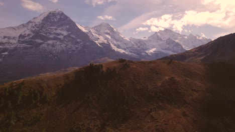 aerial-drone-footage-raising-down-in-front-of-majestic-Eiger,-Moench-and-Jungfrau-in-the-Swiss-Alps