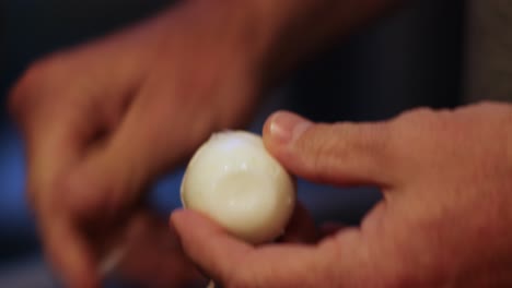 Close-up-of-man's-hands-peeling-hard-boiled-egg-with-Bokeh-background