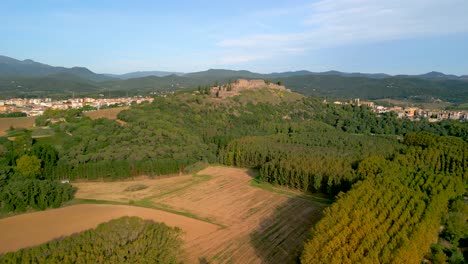 Hostalric-aerial-images-medieval-town-in-Catalonia-touristic-castle-on-top-of-the-mountain-Flight-approaching-castle-tree-farming-forestry