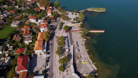 Tourist-village-of-Shiroka-in-Albania,-with-traditional-houses-and-lakeside-promenade