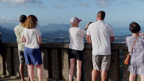 People-looking-at-a-view-on-a-windy-day-at-Pali-Lookout,-Hawaii