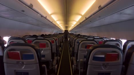 Traveling-shot-inside-an-airplane-with-people-sitting-down-during-the-flight