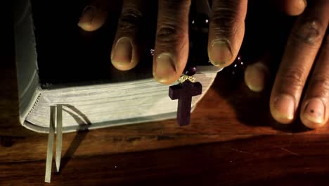 Beten-Zu-Gott-Mit-Den-Händen-Zusammen-Mit-Bibel-Und-Kreuz-Karibischer-Mann-Beten-Mit-Schwarzem-Hintergrund-Stock-Video