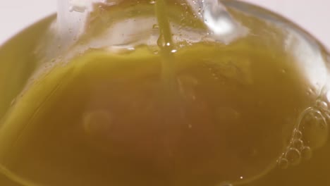 Close-up-shot-of-pouring-apple-juice-into-a-glass-bottle