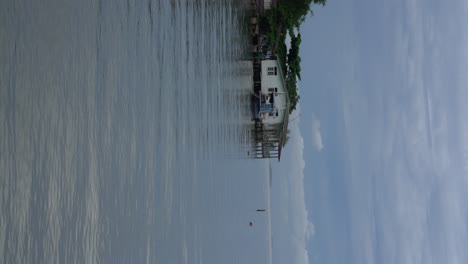 Vertical-Video---Calm-breeze-flows-through-fisherman-stilt-houses-built-on-the-sea-in-Thailand