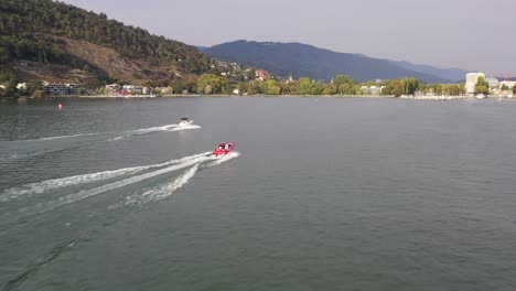Aerial-drone-footage-following-red-motorboat-on-Lake-Biel-and-showing-off-the-blue-waters-and-gorgeous-scenery