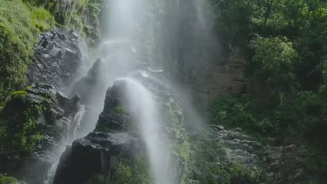 Waterfall-in-the-rainforest-flowing-over-a-huge-rock