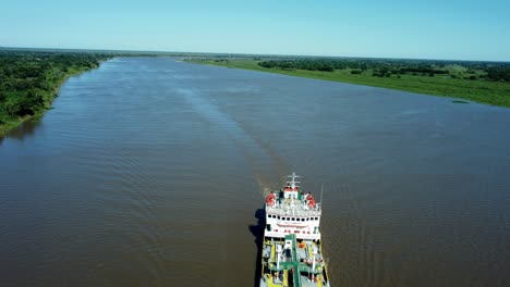 Overtake-Shot-Of-Large-Red-Commercial-Ship-Cruising-Beautiful-Blue-River,-Paraguay