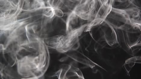 Time-rewinds-as-smoke-curls-backwards-against-a-black-background