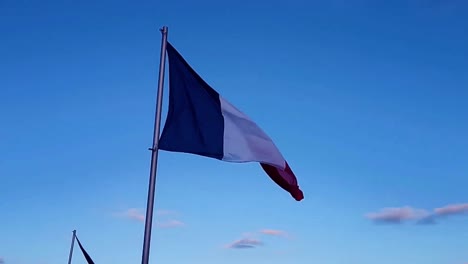 Bandera-Francesa-Ondeando-En-El-Viento-Bajo-El-Cielo-Azul